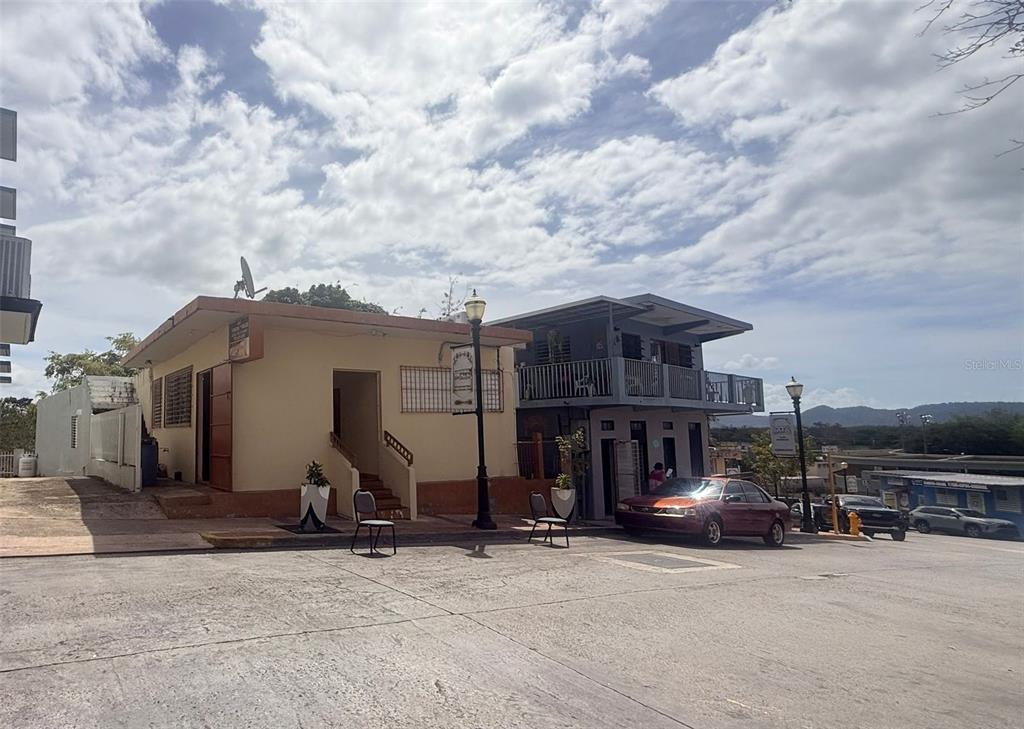 A street-level view of two adjacent commercial buildings with a parked car in front — 4 Calle Mateo Fajardo CALLE MATEO FAJARDO, HORMIGUEROS, PR