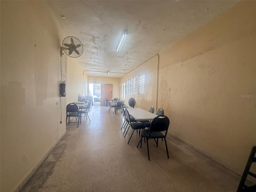 A long, narrow room with beige walls, tile flooring, tables, chairs, and a ceiling fan — 4 Calle Mateo Fajardo CALLE MATEO FAJARDO, HORMIGUEROS, PR