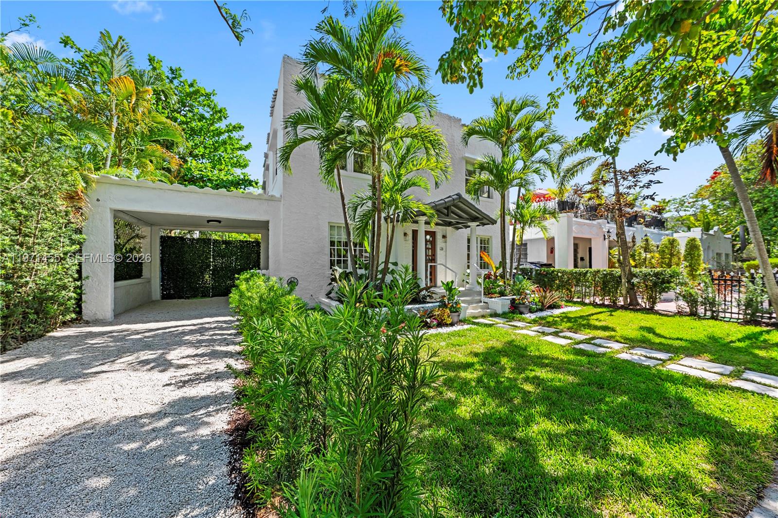 A two-story white stucco house features a gravel driveway, a carport, and palm trees — 178 NE 45th St, Miami FL 33137, MIAMI, FL