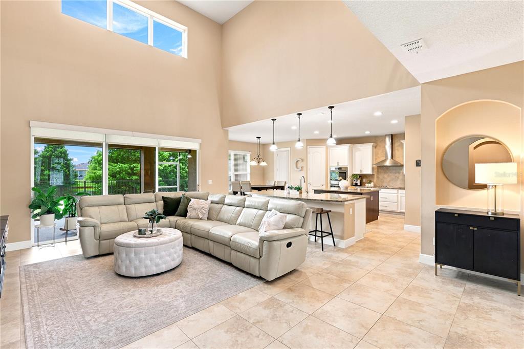 A spacious open-concept living room and kitchen featuring tile floors and high ceilings — 1177 FIELDSTONE CIRCLE, OVIEDO, FL