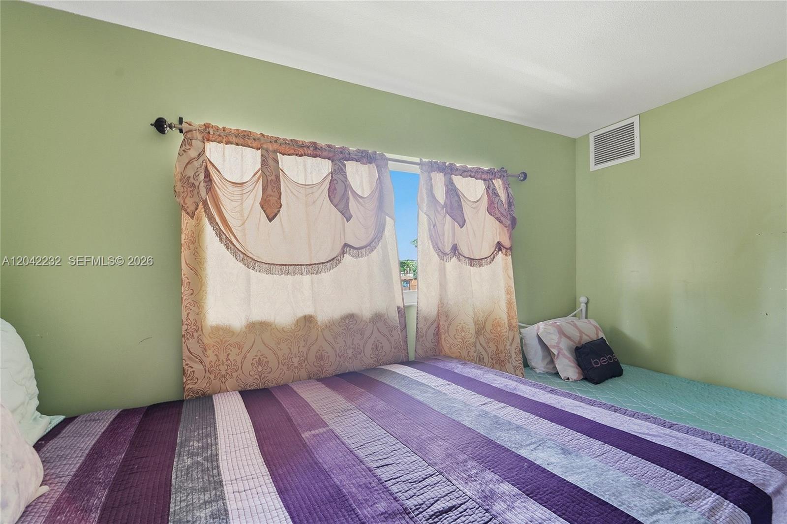 A bedroom features light green walls, a striped purple bedspread, and decorative window curtains — 2974 NW 55th Ave # 2B, Lauderhill FL 33313, LAUDERHILL, FL