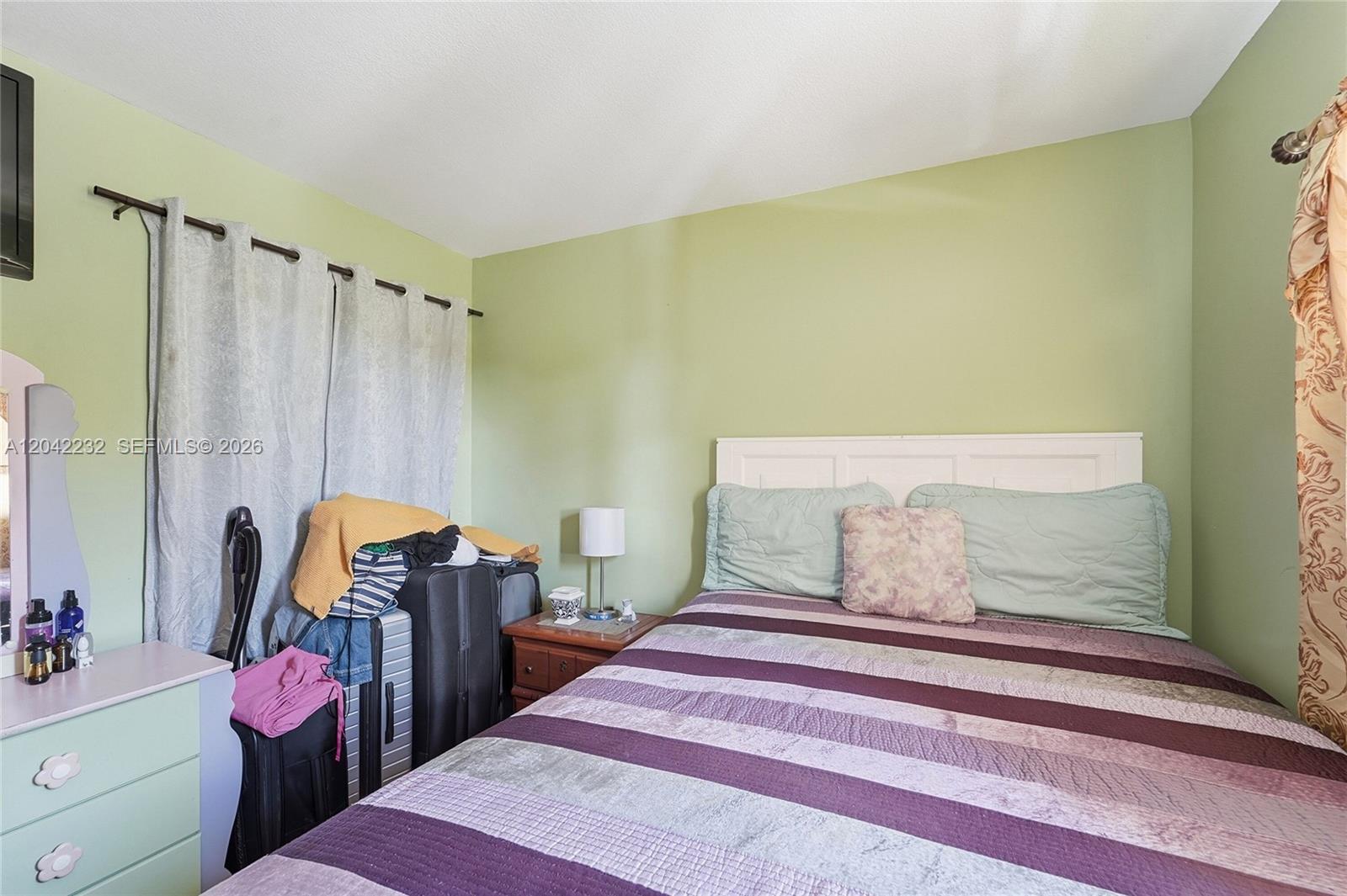 A bedroom features a bed with a striped quilt, a nightstand, and a dresser — 2974 NW 55th Ave # 2B, Lauderhill FL 33313, LAUDERHILL, FL