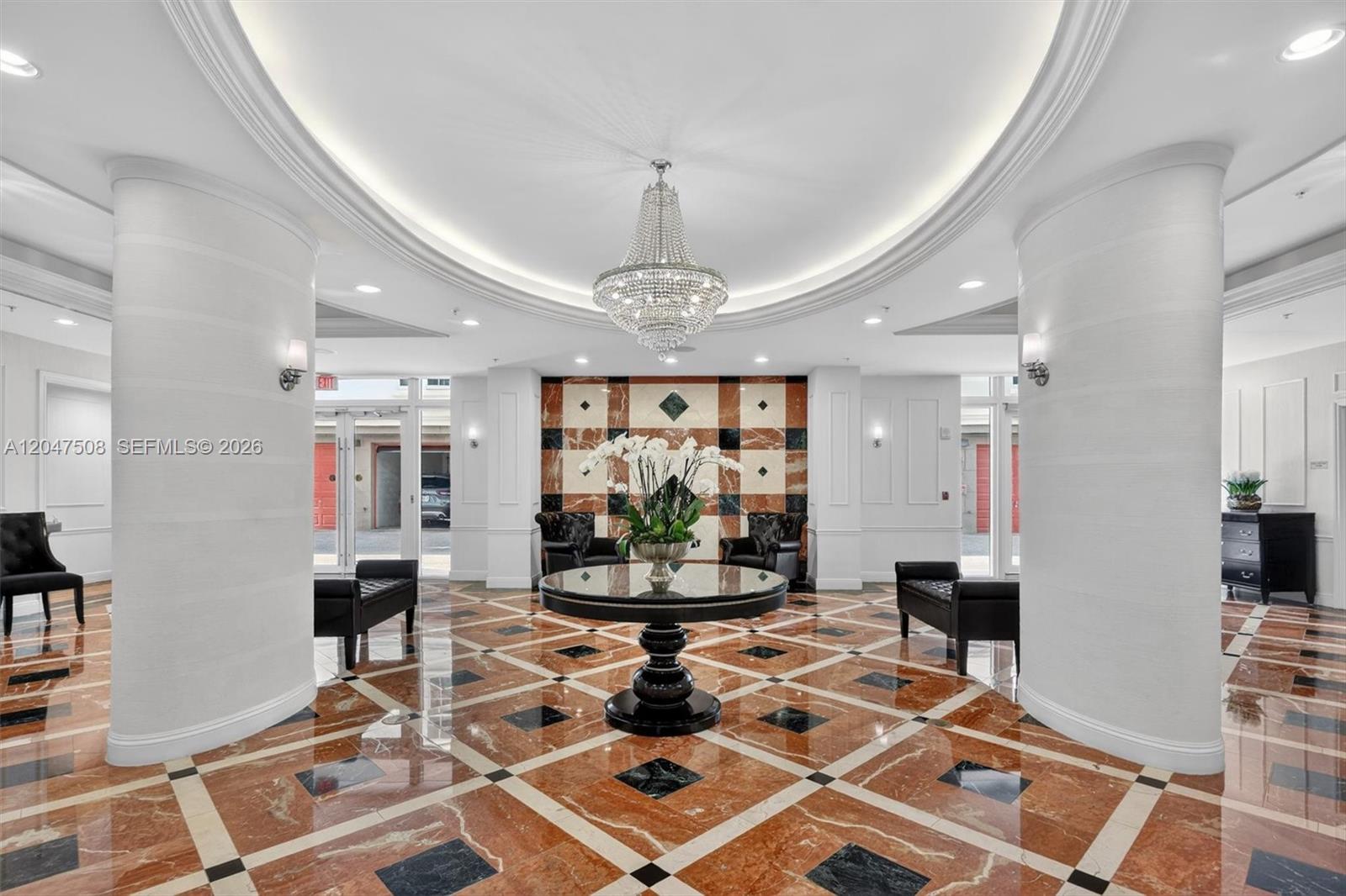 A formal lobby features a crystal chandelier, marble flooring, and a central circular table — 3232 SW Coral Way # 903, Miami FL 33145, MIAMI, FL