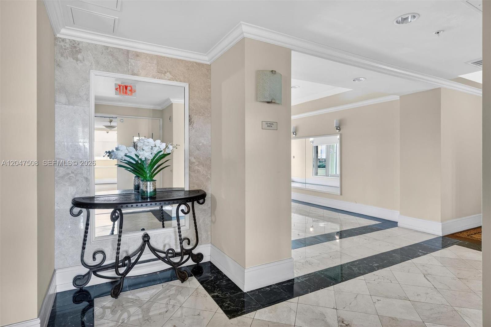 A hallway features marble floors with black borders, a console table, and a large mirror — 3232 SW Coral Way # 903, Miami FL 33145, MIAMI, FL