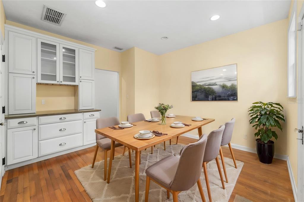A dining room features a wooden table, six chairs, a rug, and white cabinetry — 717 NE BOULEVARD, GAINESVILLE, FL