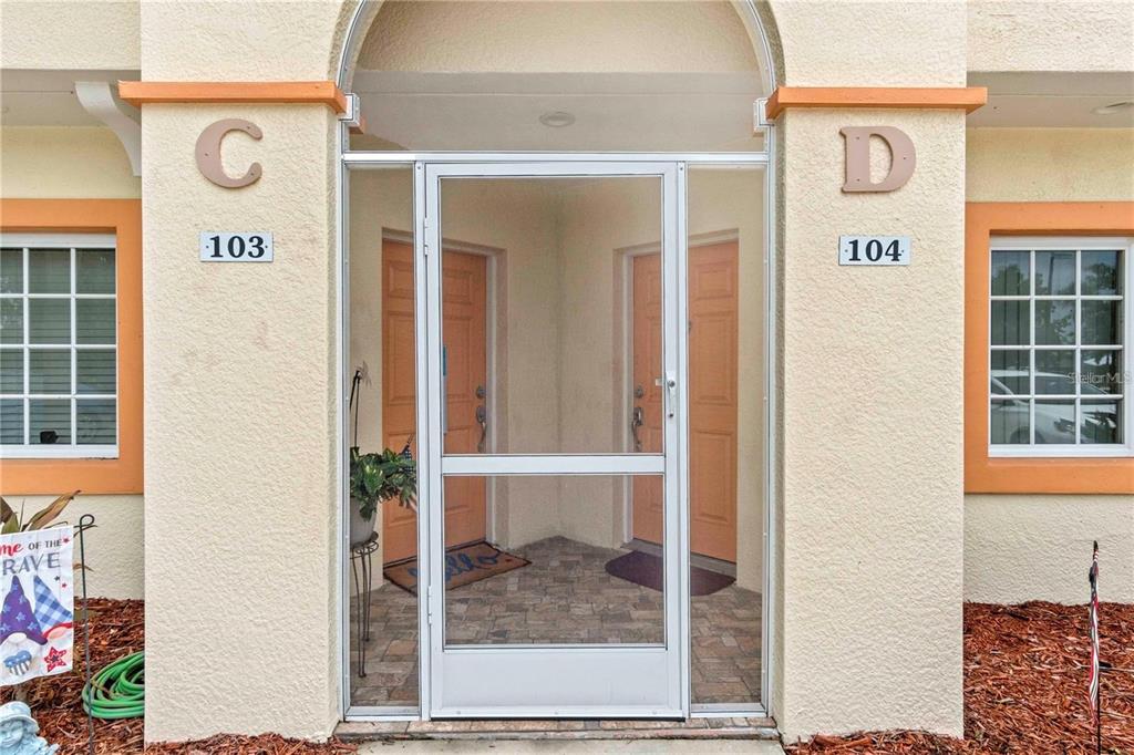 A kitchen with light wood cabinets, stainless steel appliances, and tile floors next to stairs — 1186 RIO DE JANEIRO AVENUE UNIT 104, PUNTA GORDA, FL