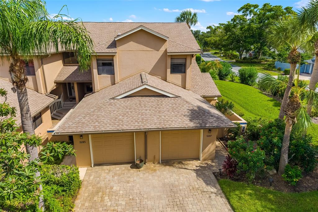 An aerial view of a two-story tan stucco townhouse with a two-car garage — 5287 HERON WAY UNIT 205, SARASOTA, FL