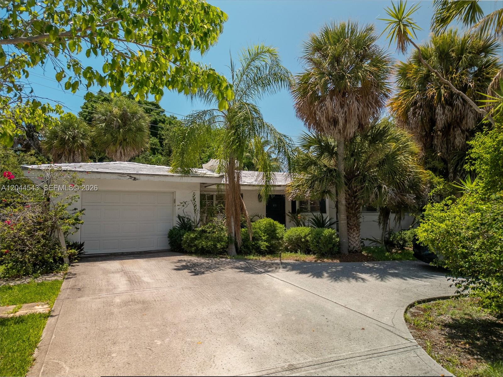 A single-story house with a white garage and palm trees sits behind a concrete driveway — 698 NW 7th Ave, Boca Raton FL 33486, BOCA RATON, FL