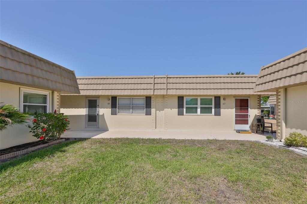 The exterior view shows two adjacent single-story residential units with beige walls and brown roofs — 202 BEDFORD STREET UNIT 68, SUN CITY CENTER, FL