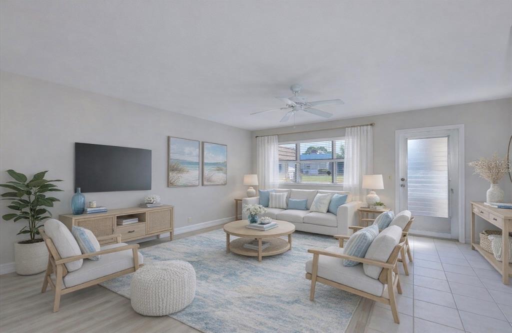 A living room features light-colored furniture, a patterned area rug, and a ceiling fan — 202 BEDFORD STREET UNIT 68, SUN CITY CENTER, FL