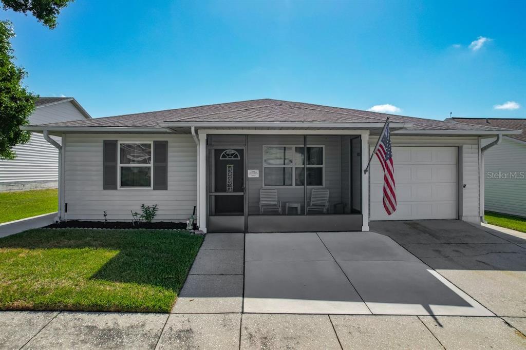 A single-story house with light gray siding, a screened-in front porch, and an attached garage — 3123 PRAIRIE DUNES CIRCLE W, LAKELAND, FL