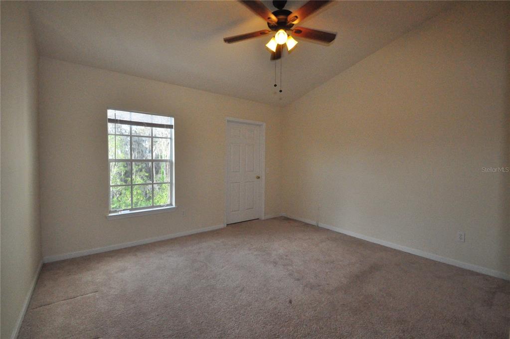 An empty bedroom features beige carpet, light-colored walls, a ceiling fan, and a window — 6530 SWISSCO DRIVE UNIT 1134, ORLANDO, FL