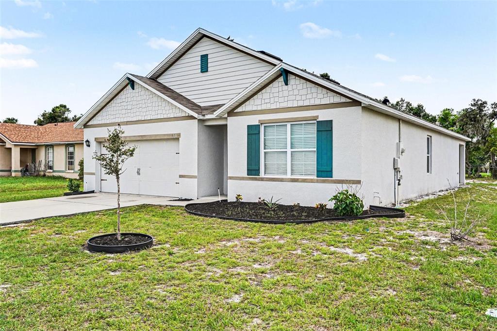 A single-story house with a white stucco exterior, blue shutters, and a two-car garage — 996 SUMMER GLEN DRIVE, WINTER HAVEN, FL