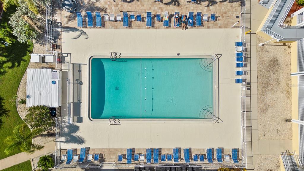 An aerial view shows a rectangular swimming pool surrounded by lounge chairs and a fence — 35 AMSTERDAM AVENUE, PUNTA GORDA, FL