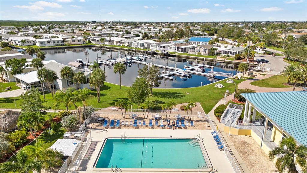 An aerial view shows a swimming pool, a marina with boat slips, and surrounding residential homes — 35 AMSTERDAM AVENUE, PUNTA GORDA, FL