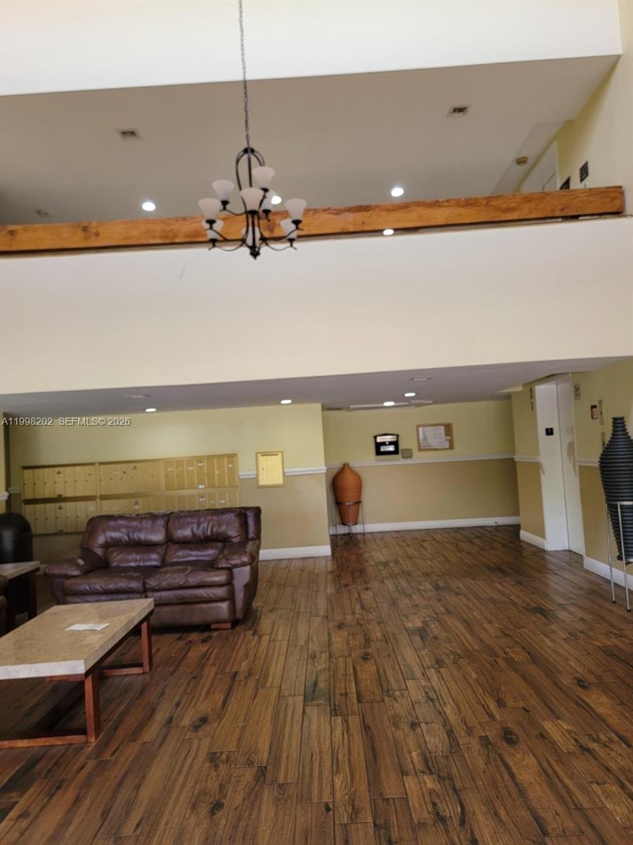 A lobby area features wood-look tile flooring, a leather sofa, mailboxes, and a wooden beam — 220 Lakeview Dr # 301, Weston FL 33326, WESTON, FL