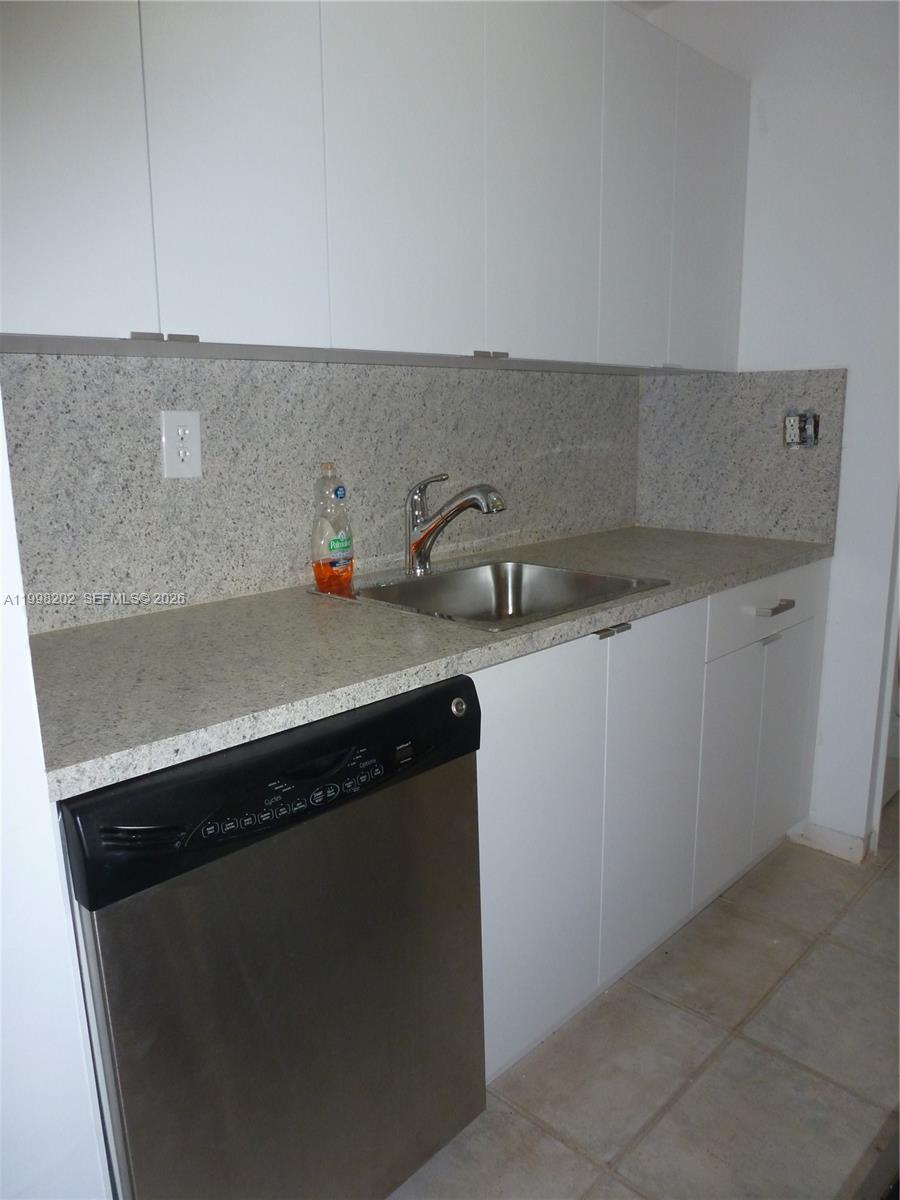 A kitchen features white cabinets, a granite countertop, a stainless steel sink, and a dishwasher — 220 Lakeview Dr # 301, Weston FL 33326, WESTON, FL