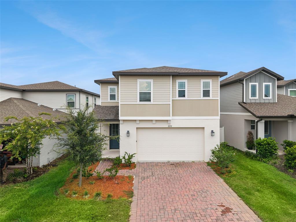 A two-story suburban house with a brick paver driveway and a two-car garage — 2292 MYSTIC MAZE LANE, CLERMONT, FL