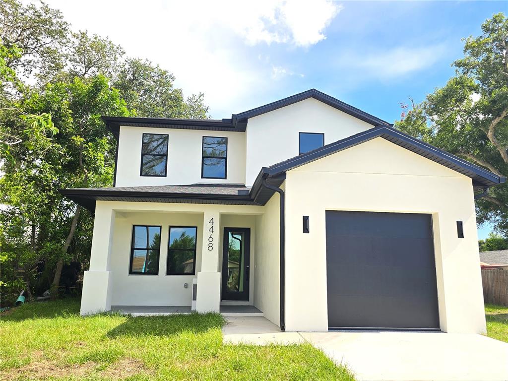 A covered front porch with a dark gray floor leads to a modern glass-paneled door — 4468 57TH AVENUE N, ST PETERSBURG, FL