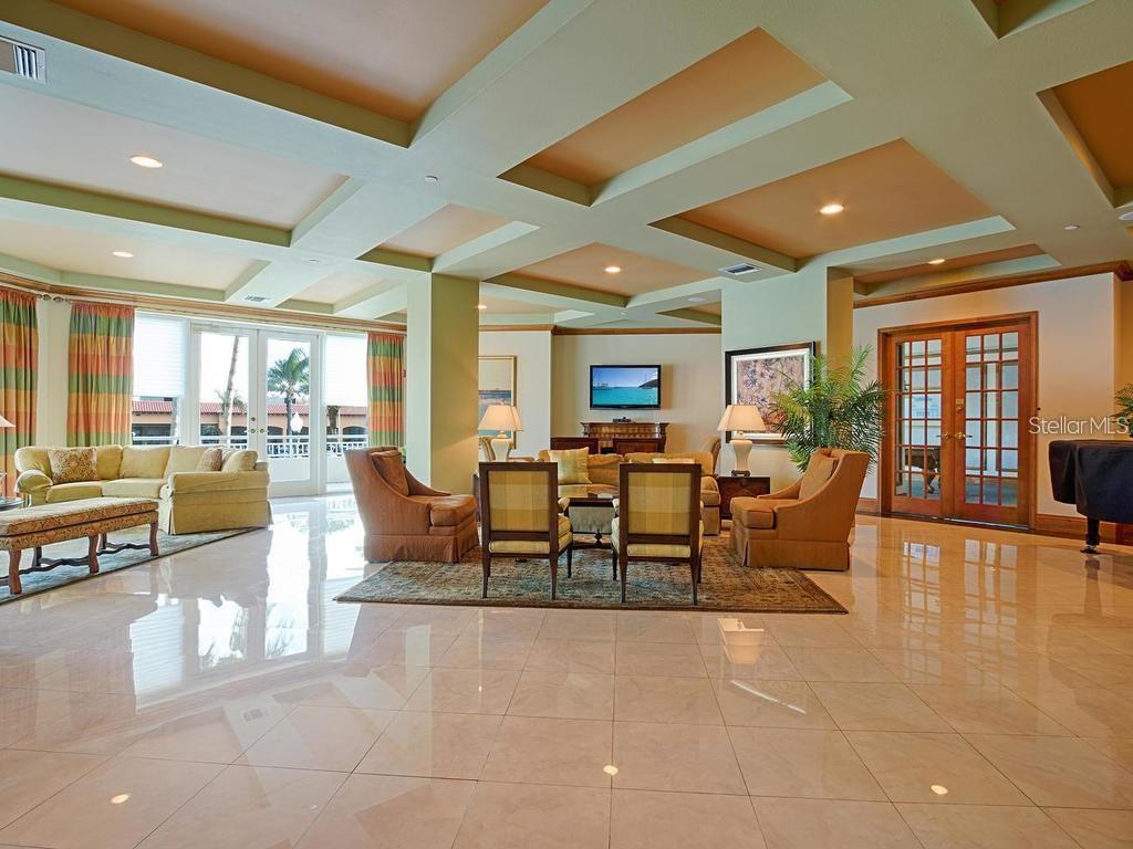 A spacious living room features a coffered ceiling, tiled floors, and multiple seating areas — 1170 GULF BOULEVARD UNIT 1803, CLEARWATER BEACH, FL