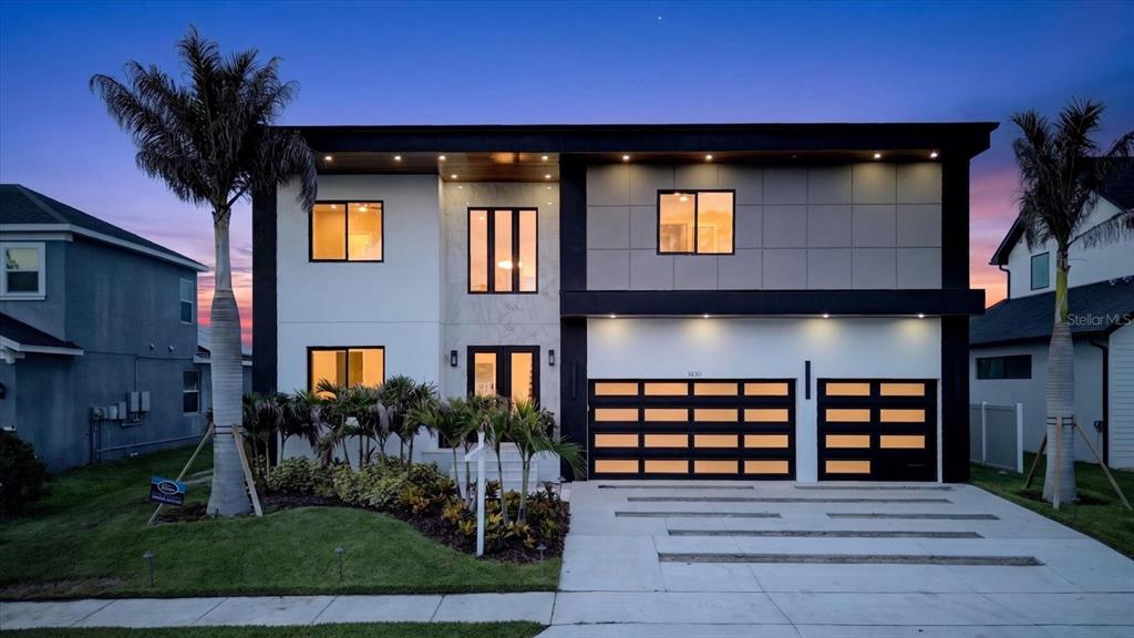 A bright foyer features a floating staircase, double glass doors, and white marble-look tile flooring — 3420 CHANNELSIDE COURT, SAFETY HARBOR, FL