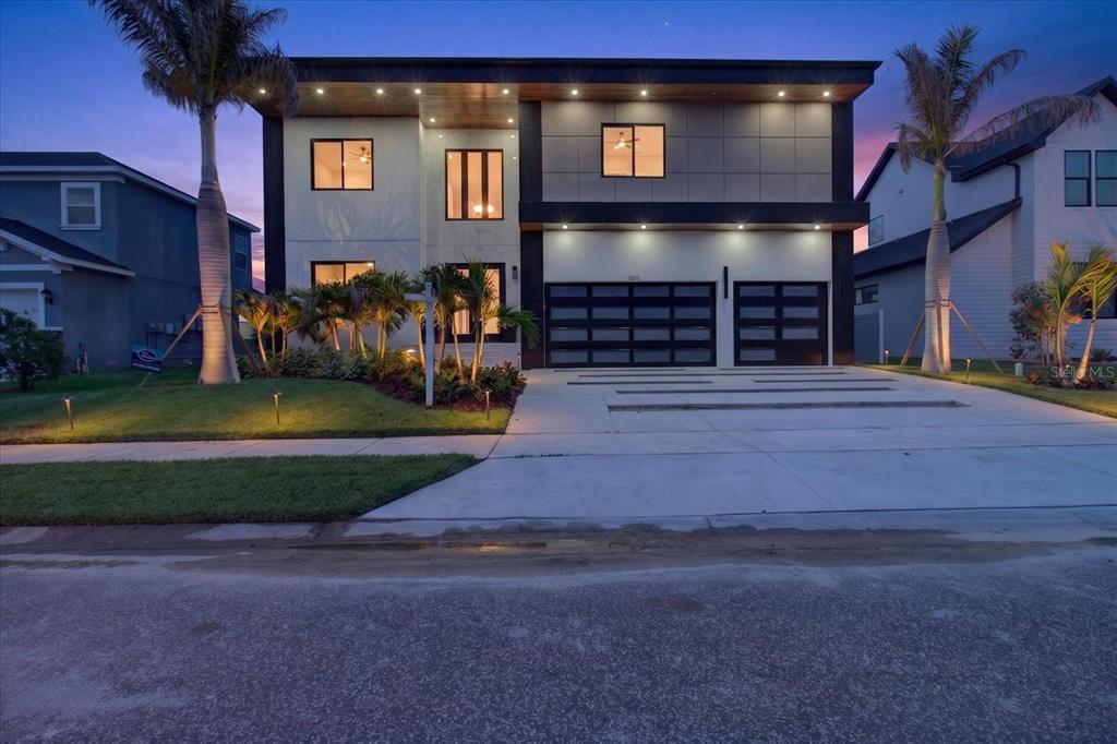 An aerial view shows a modern two-story house with a flat roof and attached garage — 3420 CHANNELSIDE COURT, SAFETY HARBOR, FL
