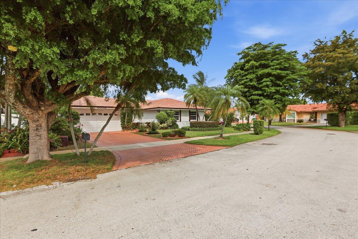 A single-story house with a white exterior, red tile roof, and a paved driveway — 20009 NW 66th Place, Hialeah FL 33015, HIALEAH, FL