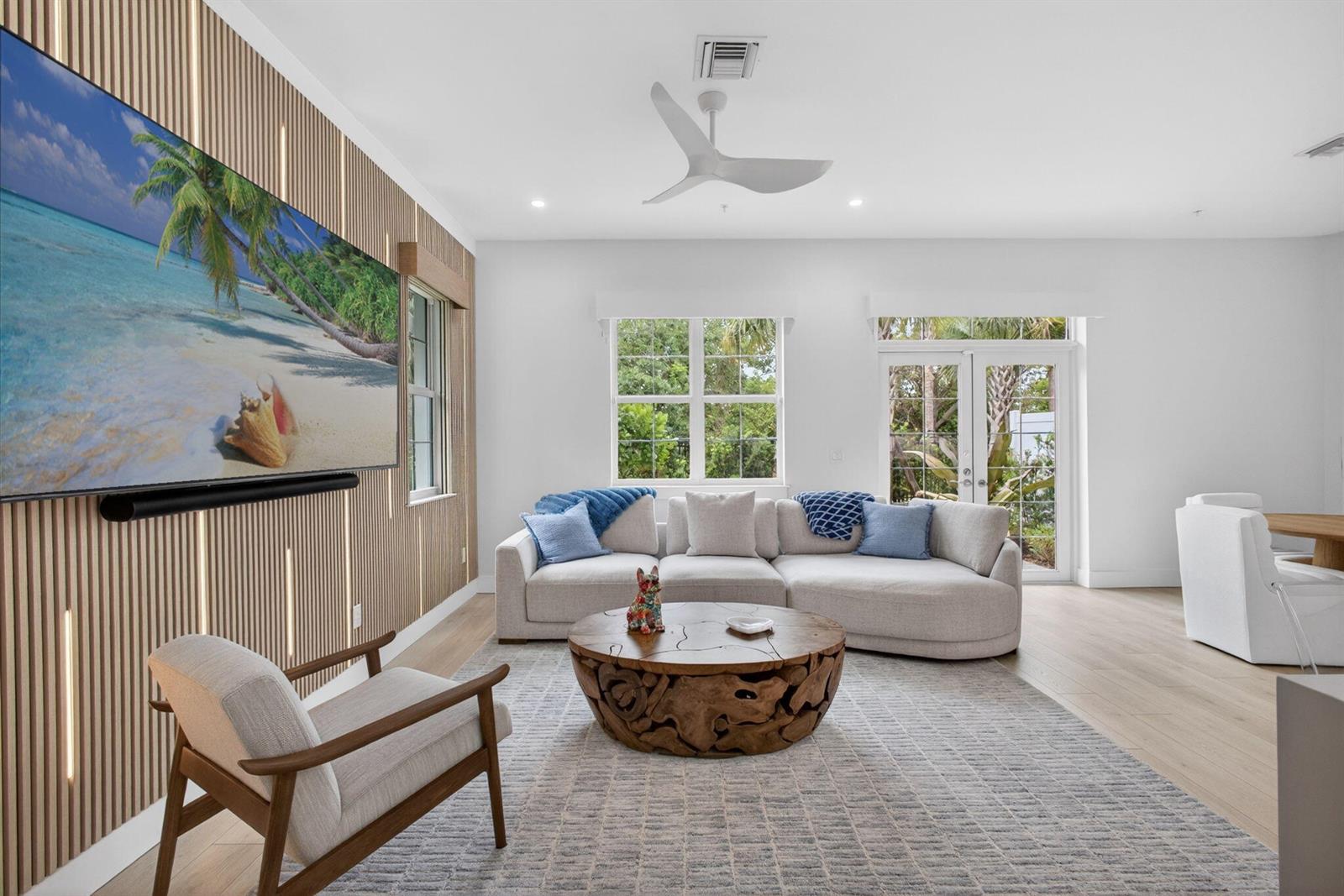 A living room features a slatted wood accent wall, a sectional sofa, and a coffee table — 130 Water Pointe Place # 7, Jupiter FL 33477, JUPITER, FL