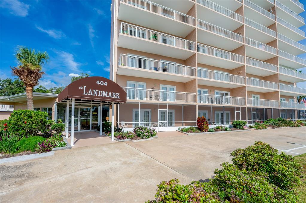 A multi-story apartment building with balconies and a covered entrance labeled The Landmark — 404 S BEACH STREET UNIT 503, DAYTONA BEACH, FL