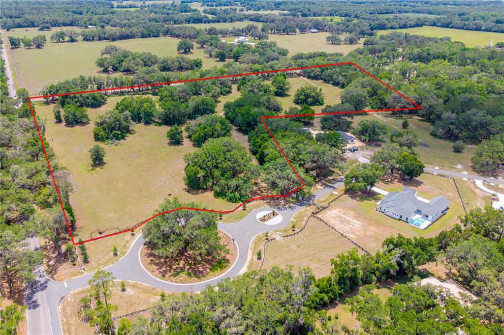 An aerial view shows a large, fenced plot of land with trees and a driveway — TBD SW 170TH STREET, NEWBERRY, FL