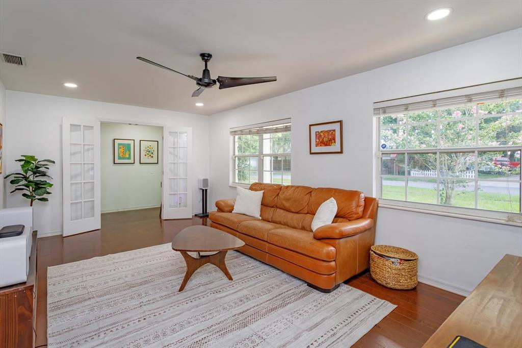 A living room features a leather sofa, a wooden coffee table, and a patterned rug — 6412 STOCKBRIDGE AVENUE, ORLANDO, FL