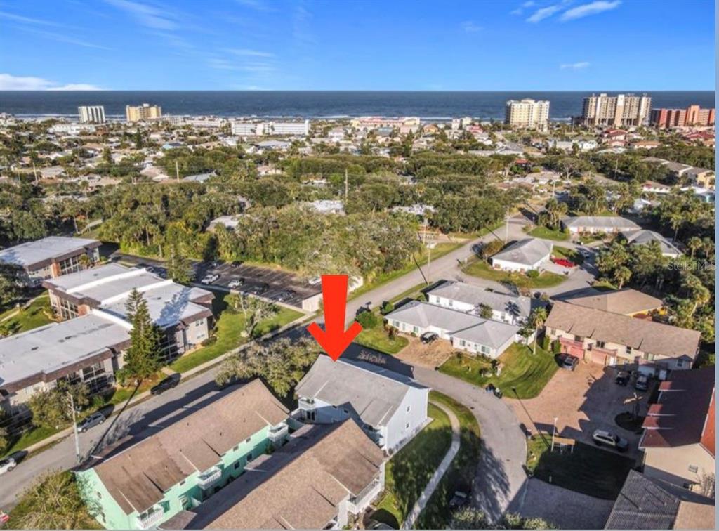 An aerial view shows a multi-story residential building with a red arrow pointing downward — 742 LAUREL BAY CIRCLE, NEW SMYRNA BEACH, FL
