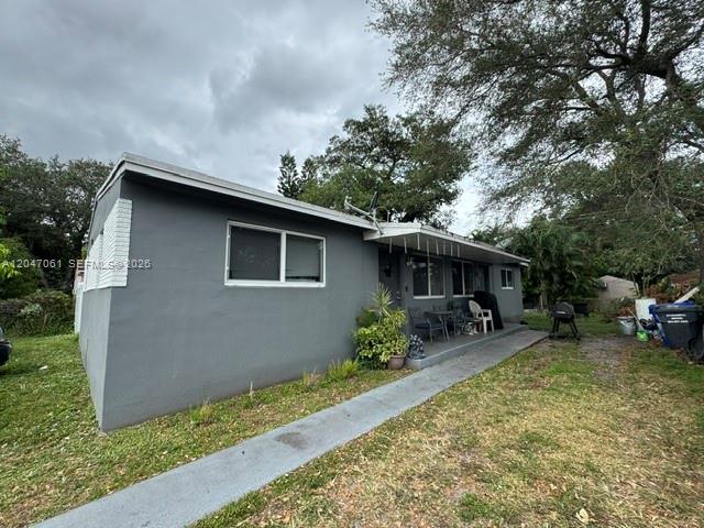 A gray, single-story house with a concrete walkway and a small patio area — 6351 Hayes St, Hollywood FL 33024, HOLLYWOOD, FL