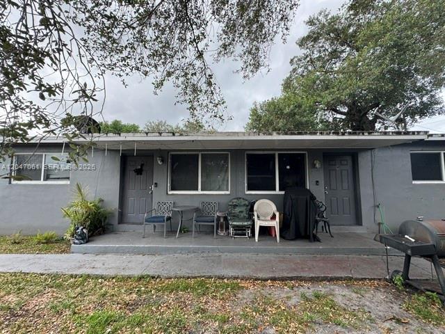A gray single-story building features two entry doors, windows, and a concrete patio area — 6351 Hayes St, Hollywood FL 33024, HOLLYWOOD, FL