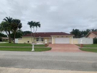 A single-story house with a red roof, a fountain, and a two-car garage — WELLINGTON, FL