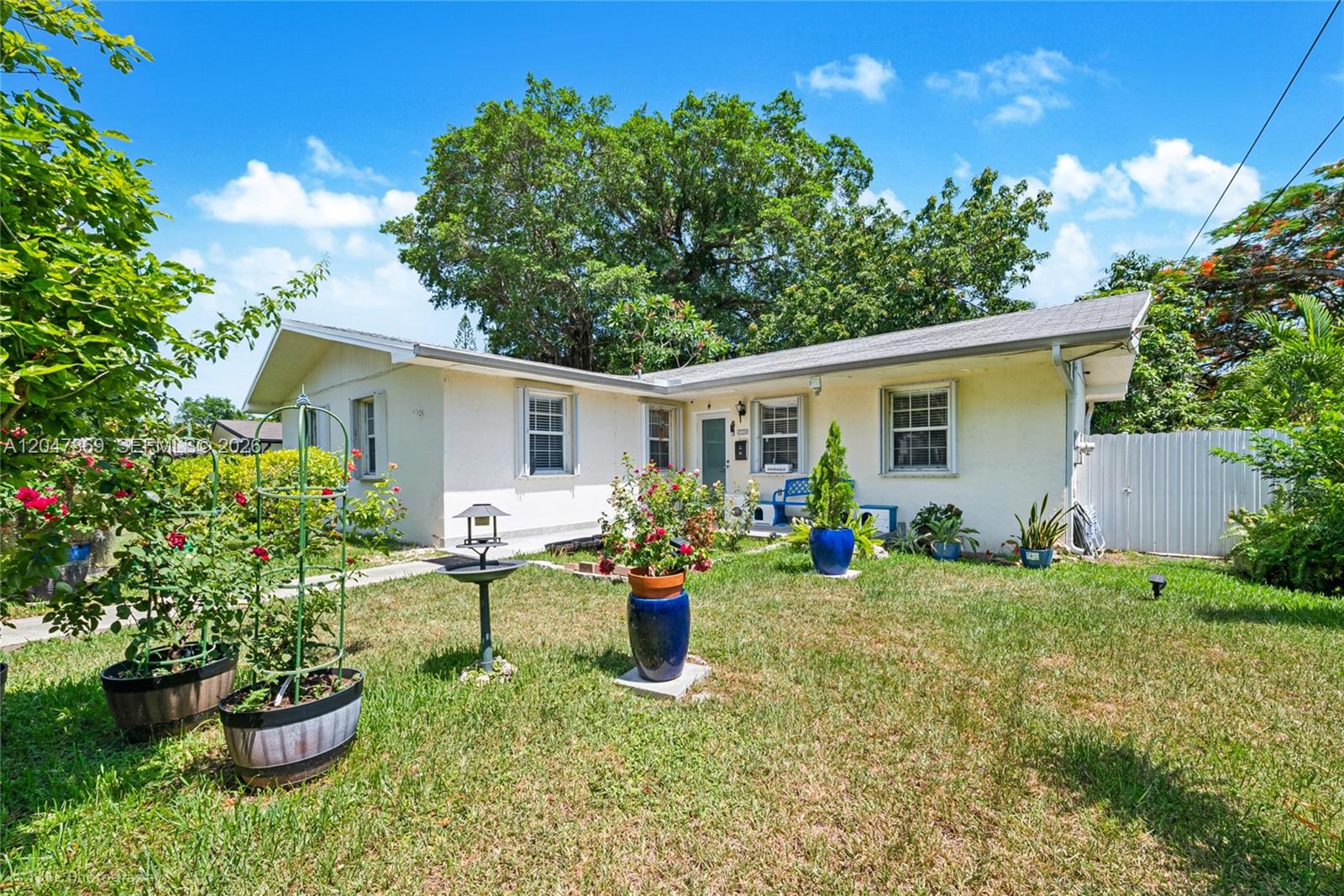 A single-story house with a white exterior, a lawn, and potted plants in the front yard — 3750 Percival Ave, Miami FL 33133, MIAMI, FL
