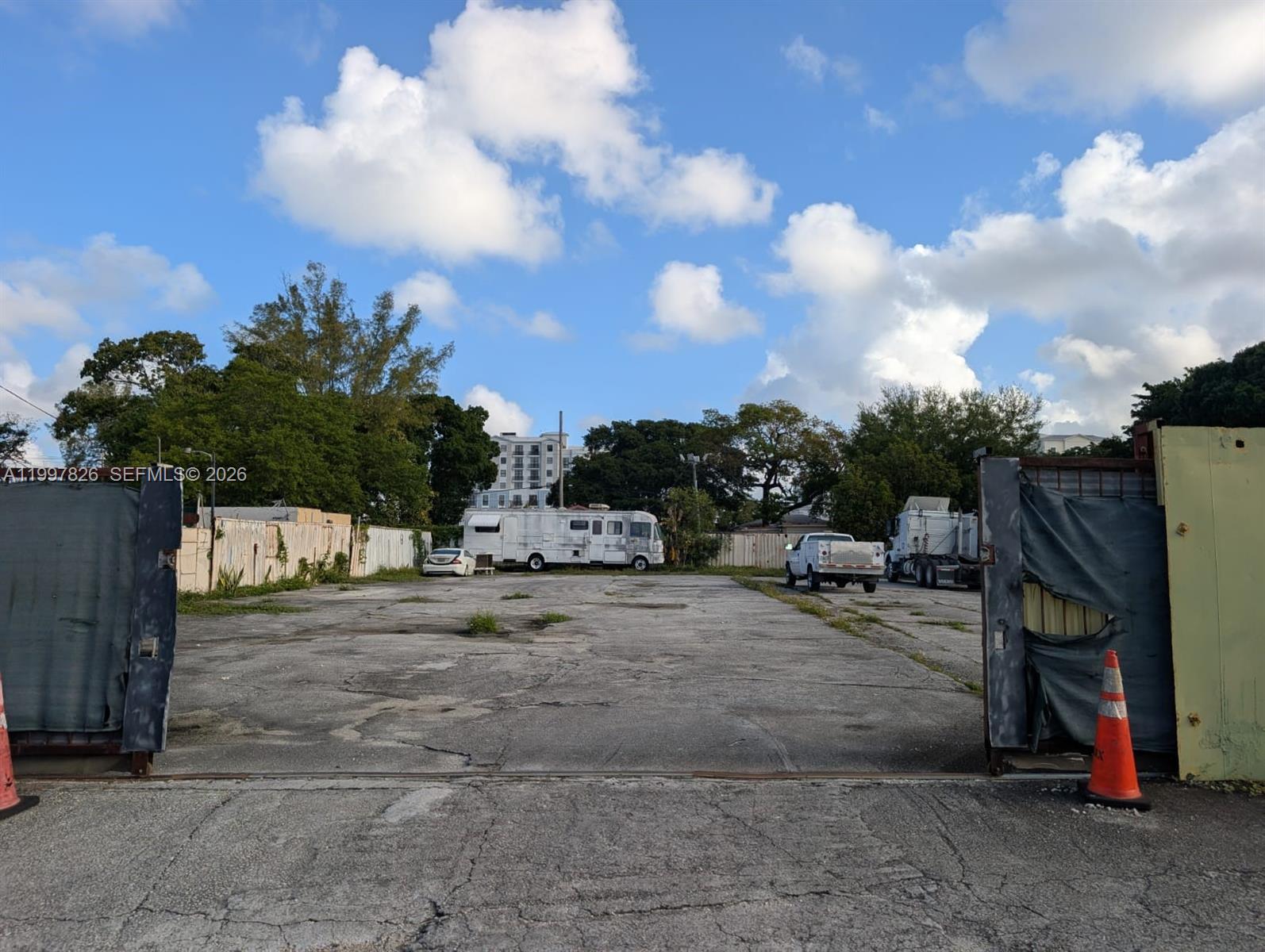 An open, paved outdoor lot features a parked RV, a white truck, and perimeter fencing — 3175 NW 75TH STREET, Miami FL 33147, MIAMI, FL