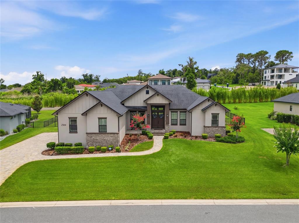 A single-story house with a gray roof, stone accents, and a paved driveway — 2564 DELPHI WOODS CIRCLE, LAKELAND, FL