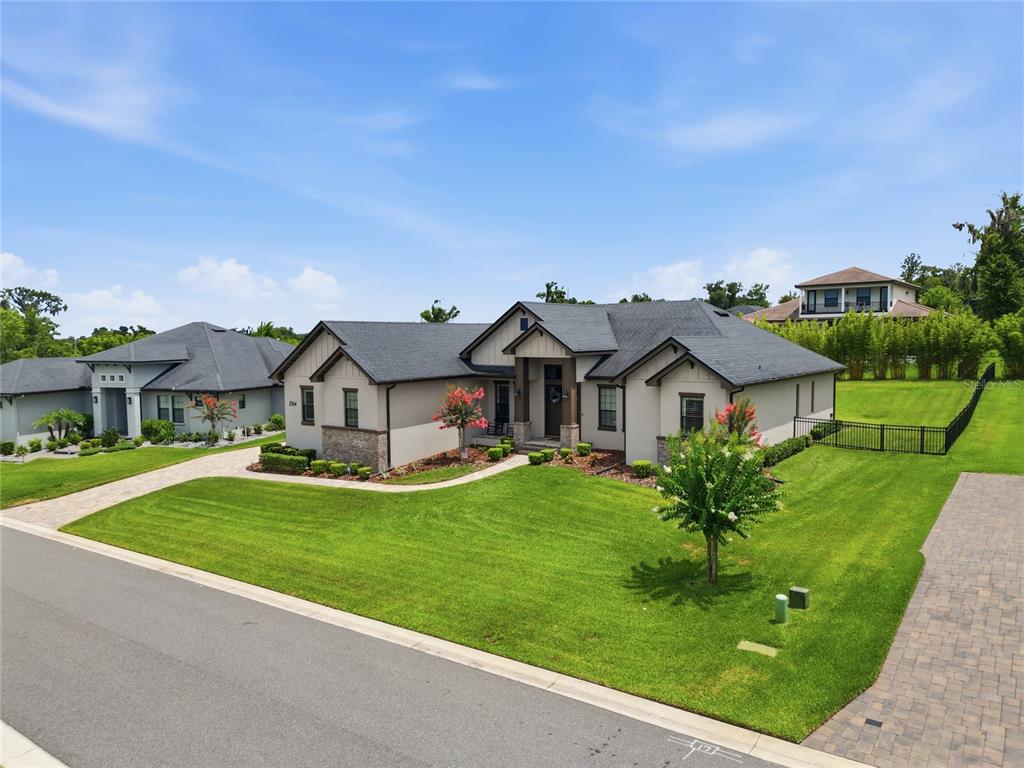 An exterior view of a single-story house with a paved driveway and a green lawn — 2564 DELPHI WOODS CIRCLE, LAKELAND, FL