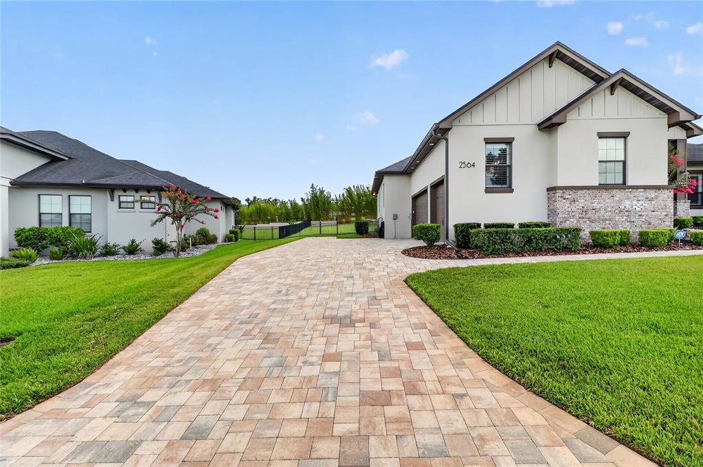 A paved driveway leads to the side entrance and garage of a suburban house — 2564 DELPHI WOODS CIRCLE, LAKELAND, FL