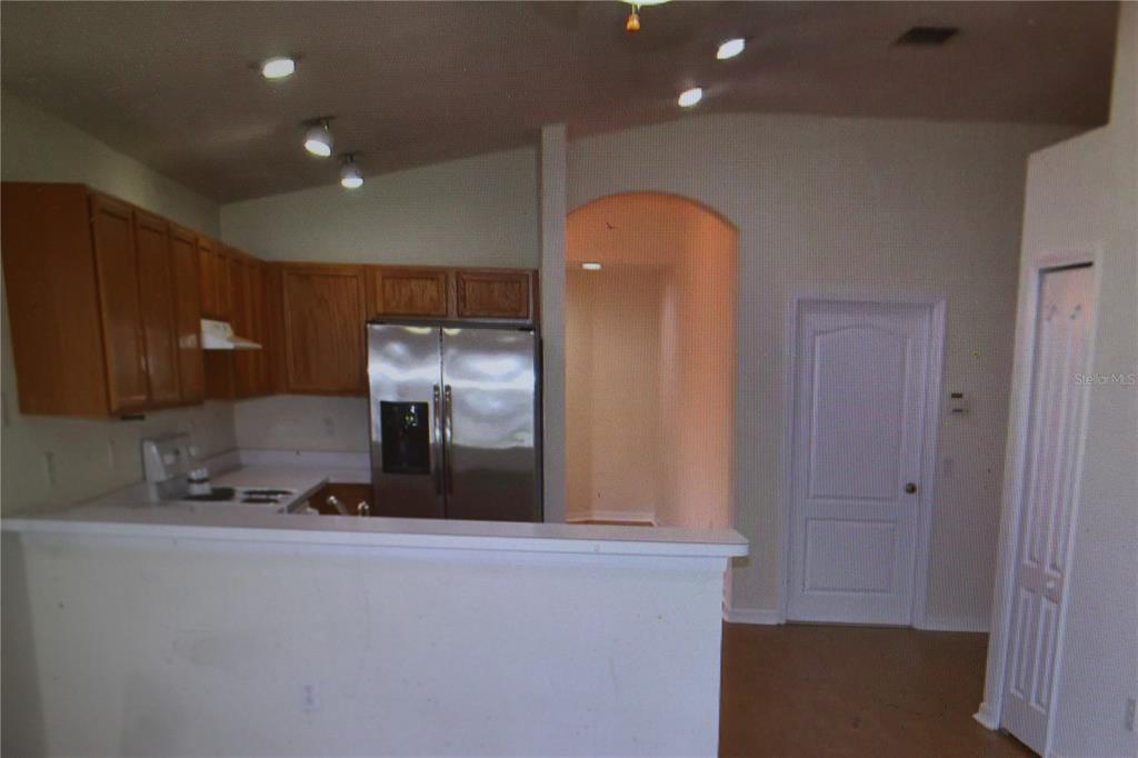 A kitchen with wood cabinets, stainless steel appliances, and a white breakfast bar — 25947 TERRAWOOD LOOP, LAND O LAKES, FL