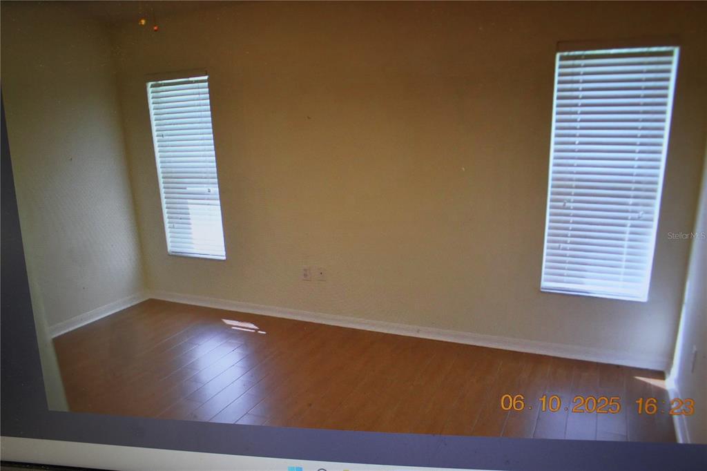 An empty room features light-colored walls, wood-look flooring, and two windows with white blinds — 25947 TERRAWOOD LOOP, LAND O LAKES, FL