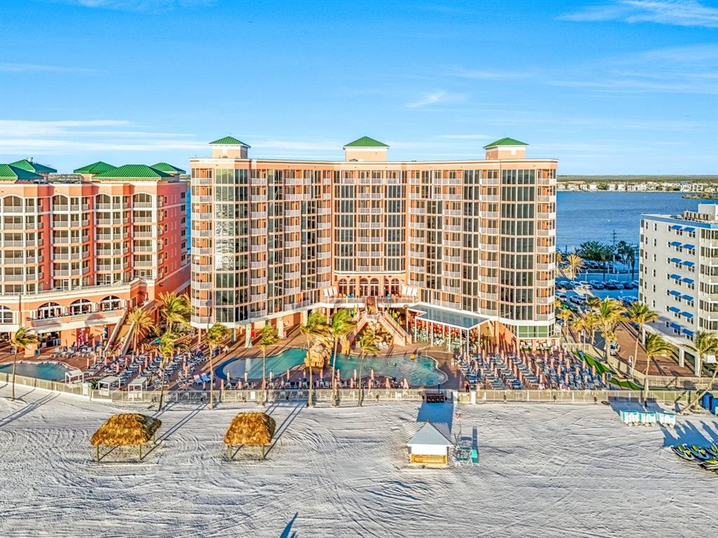 An aerial view of a large beachfront resort hotel with pools and palm trees — 200 ESTERO BOULEVARD UNIT 207, FORT MYERS BEACH, FL