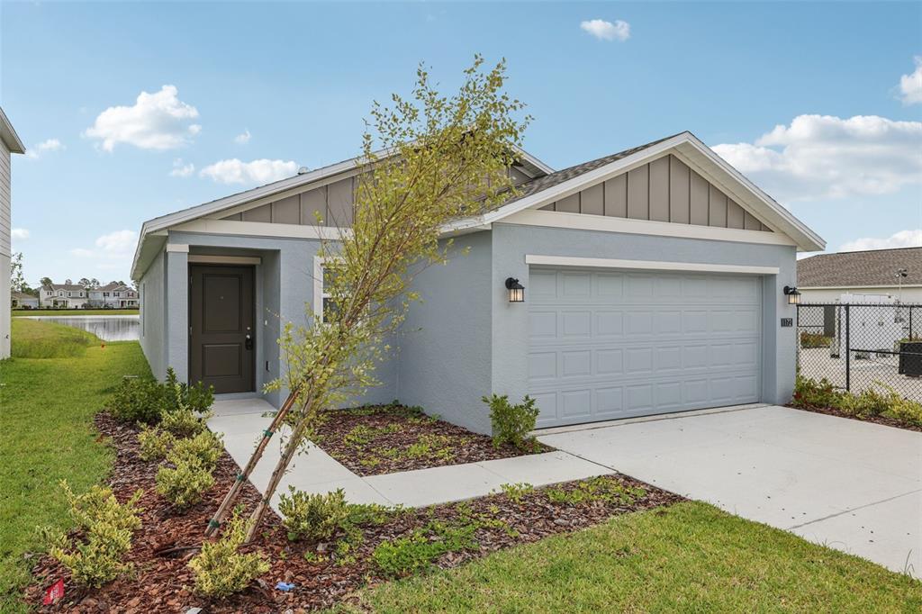 A single-story house with a light blue exterior, a two-car garage, and a front walkway — 1172 BELLE ISLE LANE, DAYTONA BEACH, FL