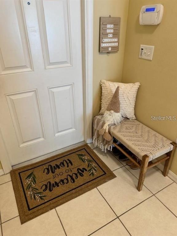 An entryway features a white door, a welcome mat, and a small wooden bench — 20418 NEEDLETREE DRIVE, TAMPA, FL