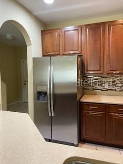 A kitchen features stainless steel appliances, wood cabinets, and a light-colored countertop — 20418 NEEDLETREE DRIVE, TAMPA, FL