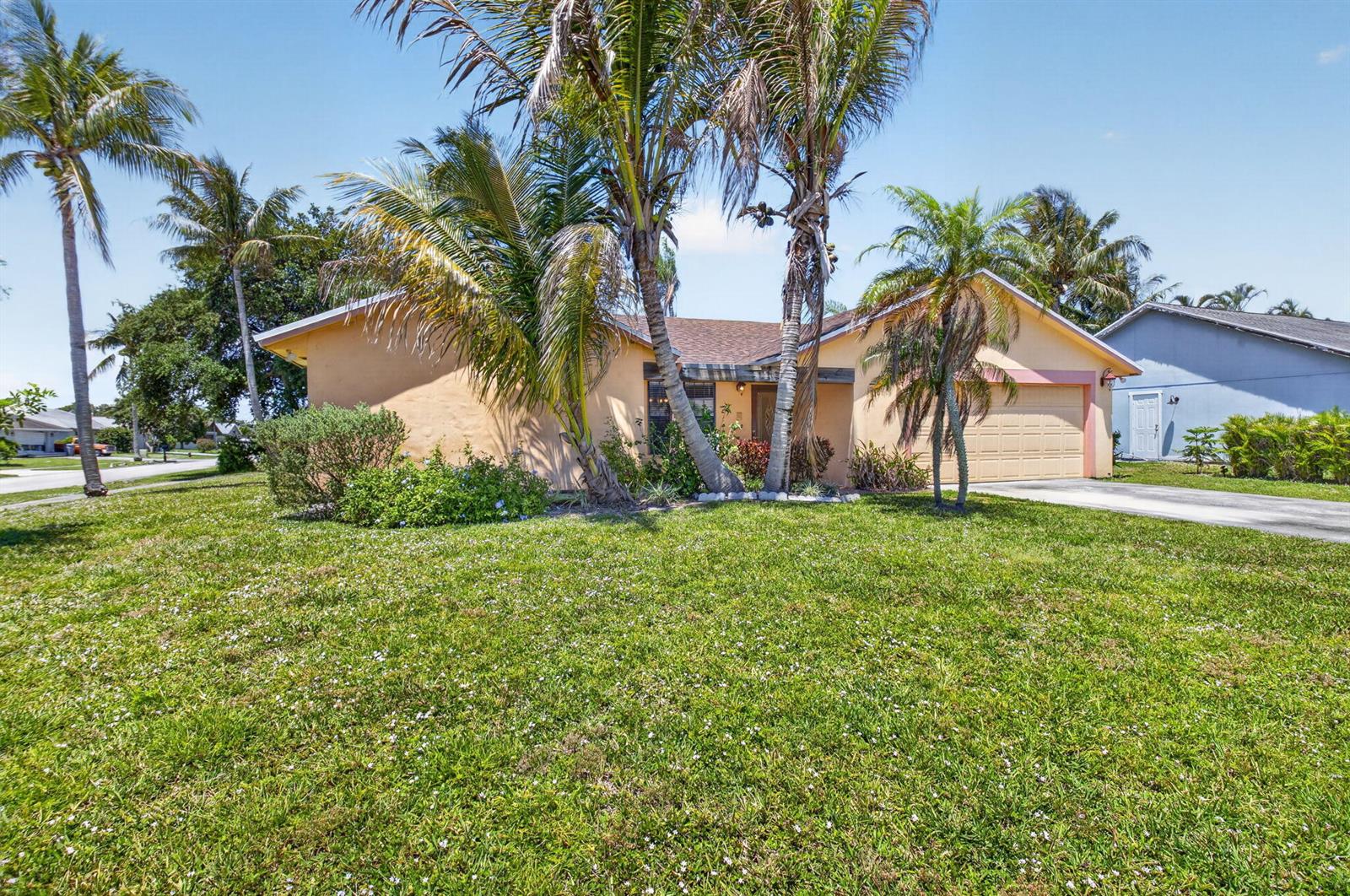 A single-story house with a tan exterior, a two-car garage, and several palm trees — 9389 Longmeadow Circle, Boynton Beach FL 33436, BOYNTON BEACH, FL