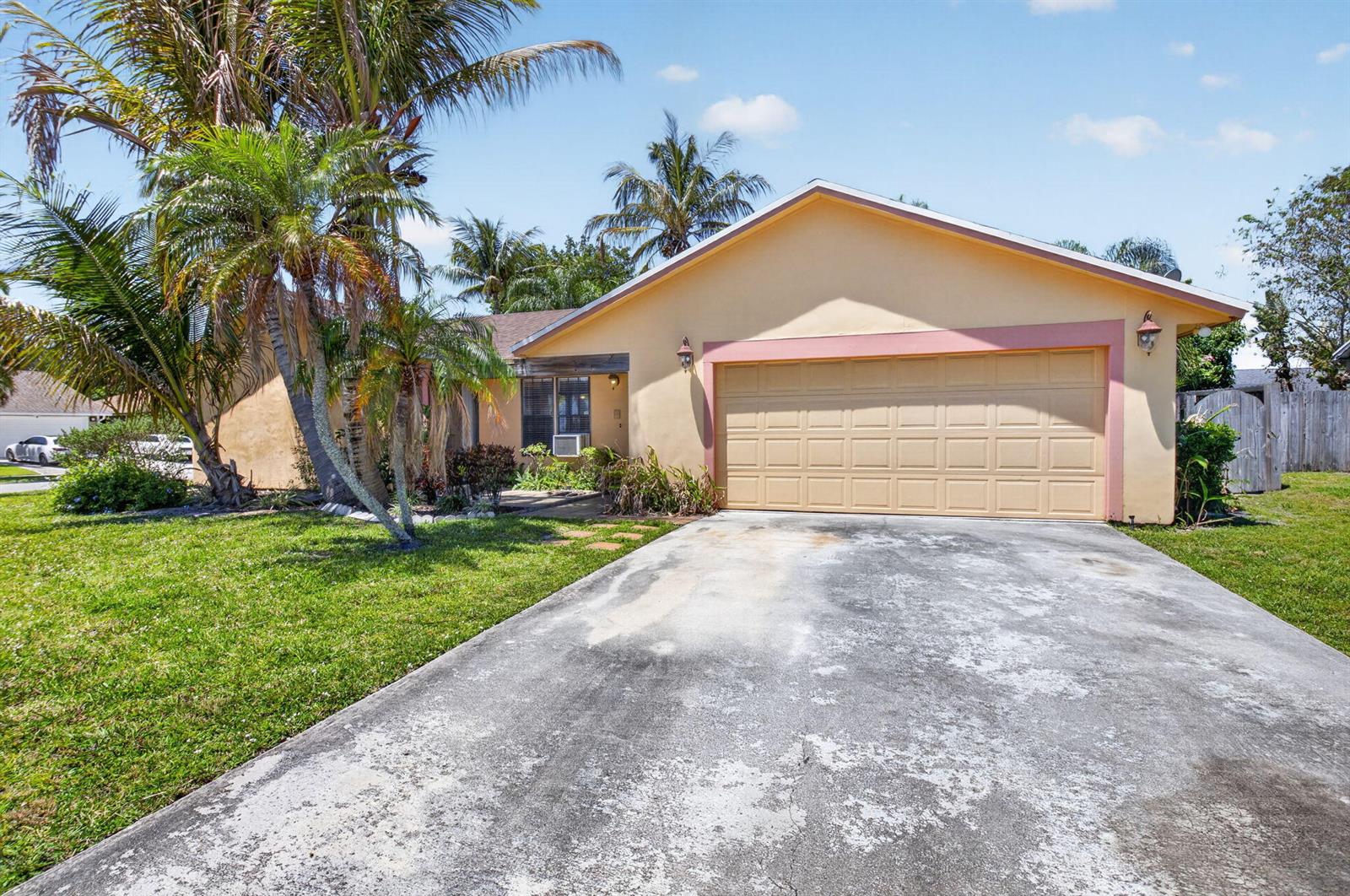 A single-story house with a beige exterior, a two-car garage, and palm trees — 9389 Longmeadow Circle, Boynton Beach FL 33436, BOYNTON BEACH, FL