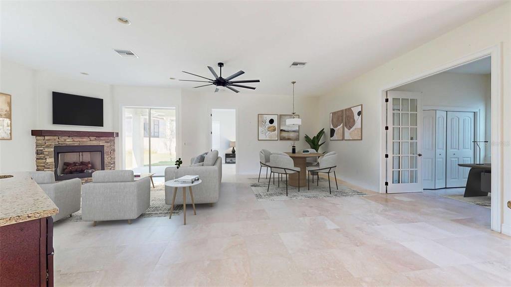 A bright open-concept living and dining area features a stone fireplace and tile flooring — 9129 S DEER PARK DRIVE, HOMOSASSA, FL