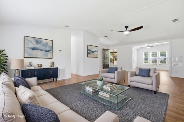 A living room features light wood floors, a gray area rug, and neutral-toned furniture — 24225 DUFFIELD ROAD, BROOKSVILLE, FL